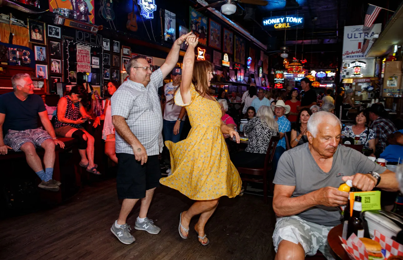 A country band playing live on a brightly lit stage on Lower Broadway